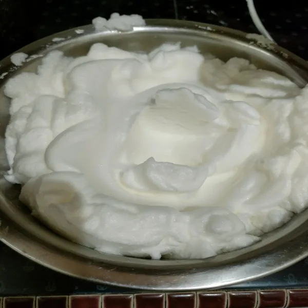 Mixer putih telur bersama cream of tartar hingga berbuih lalu masukkan 1 sdm gula pasir dan mixer hingga soft peak.