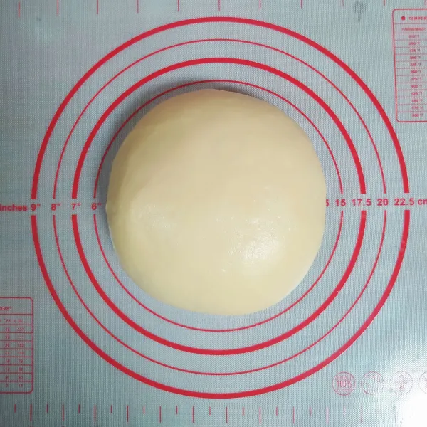 Bulatkan adonan (baluri tangan dengan margarin supaya tidak lengket), letakkan di meja, lalu tutup dengan wadah/baskom. Diamkan  selama 20-30 menit.