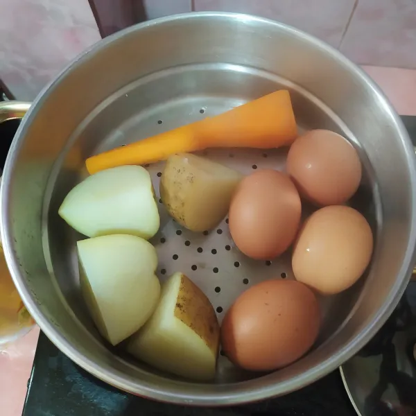 Kukus wortel, kentang dan telur hingga matang.