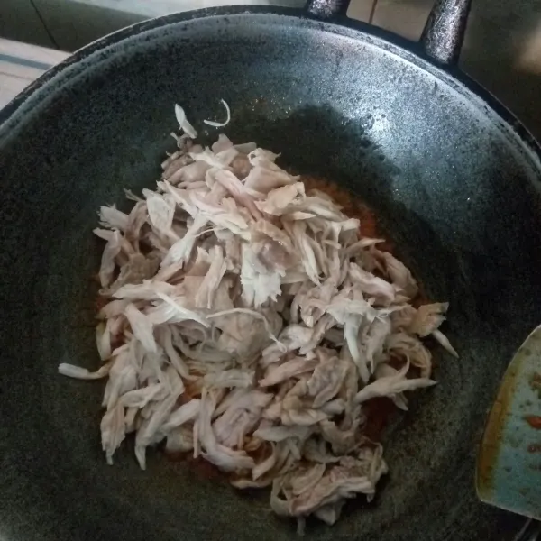 Tambahkan ayam yang sudah disuwir, aduk hingga tercampur rata dengan bumbu.