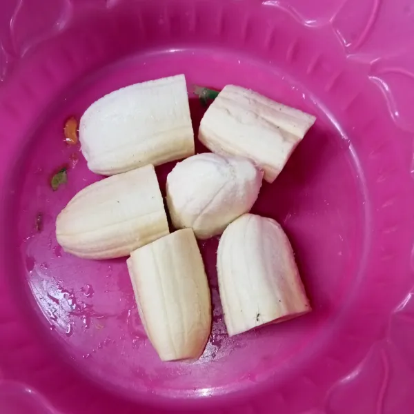 Kupas pisang dan potong jadi dua bagian (kalau pisangnya besar potong jadi tiga).