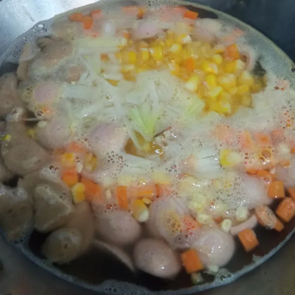 Kemudian masukkan bawang bombay dan wortel, masak hingga setengah matang lalu masukkan jagung dan masak hingga mendidih.