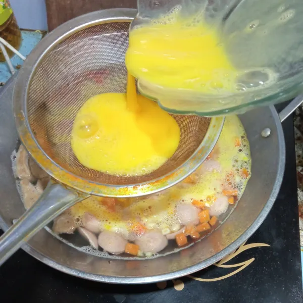 Kemudian tuang telur dengan menggunakan saringan, aduk.