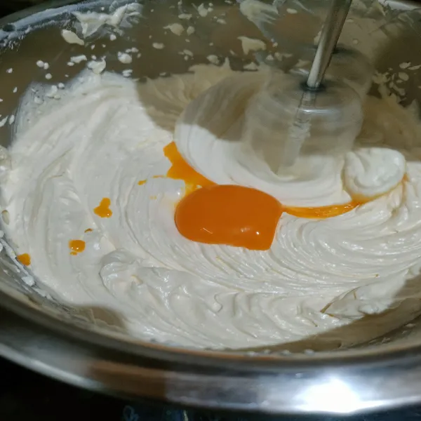 Masukkan kuning telur secara bertahap sambil di mixer dengan kecepatan rendah dan sampai telur benar-benar tercampur rata.