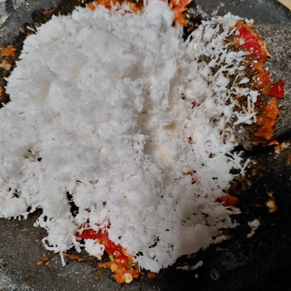Lalu masukan kelapa parut kedalam bumbu,sambil di ulek secara perlahan agar kelapa menyatu dengan bumbu.