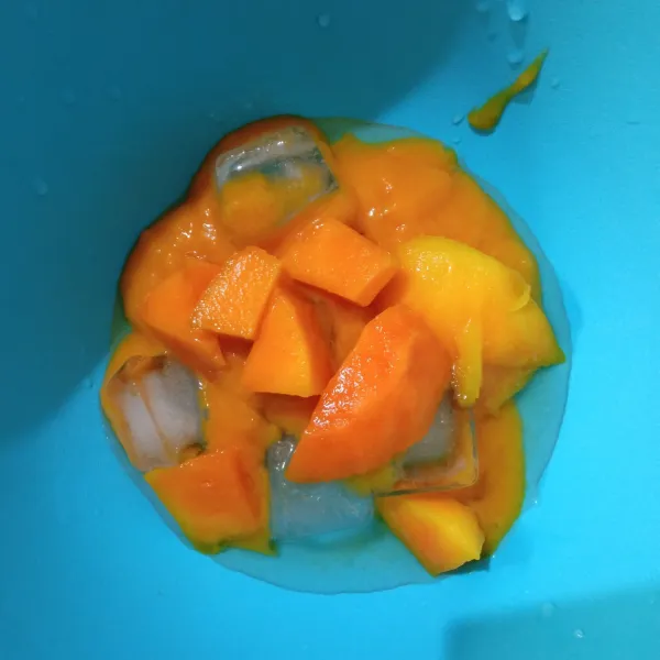 Kemudian tuang ke dalam wadah yang telah diberi es batu, lalu tambahkan potongan buah mangga.