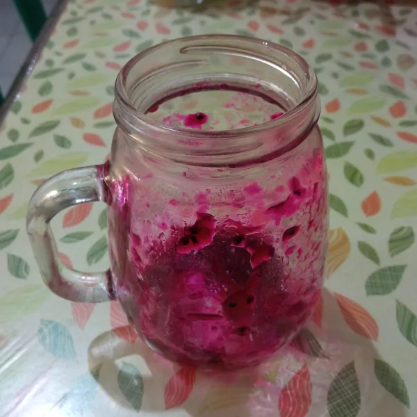Siapkan gelas saji, kemudian baluri bagian semua bagian dalam dinding gelas dengan selai buah naga.