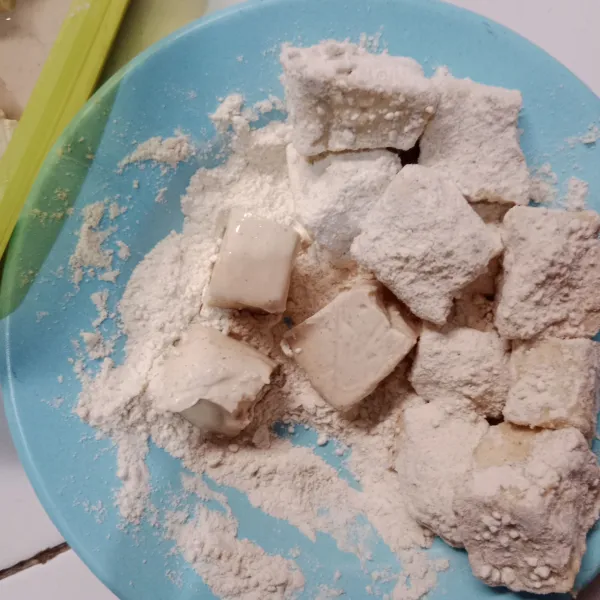 Siapkan wadah berisi tepung bumbu, gulingkan tahu yang sudah dimarinasi ke dalam tepung bumbu.
