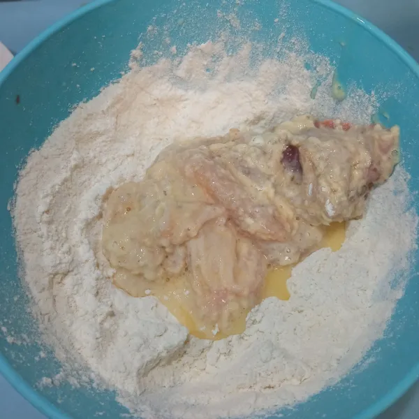 Lalu gulingkan kembali kedalam tepung mix, baluri hingga semua permukaan ayam tertutup tepung, sambil sedikit dicubit-cubit.