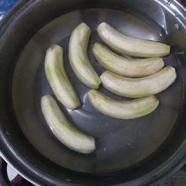 Kupas pisang mentah, lalu cuci bersih.