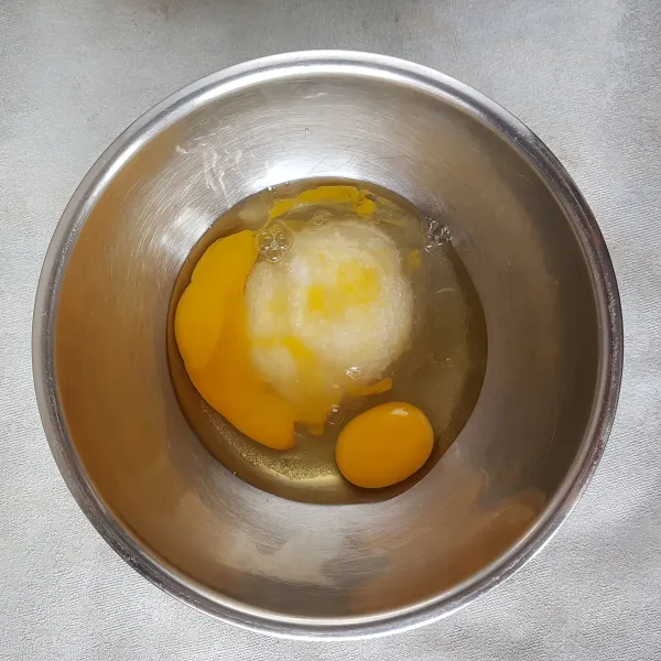 Selagi menunggu lapisan keju di kukus,buat adonan bolu pisang. Masukkan telur dan gula pasir,kocok dengan whisk hingga gula larut.