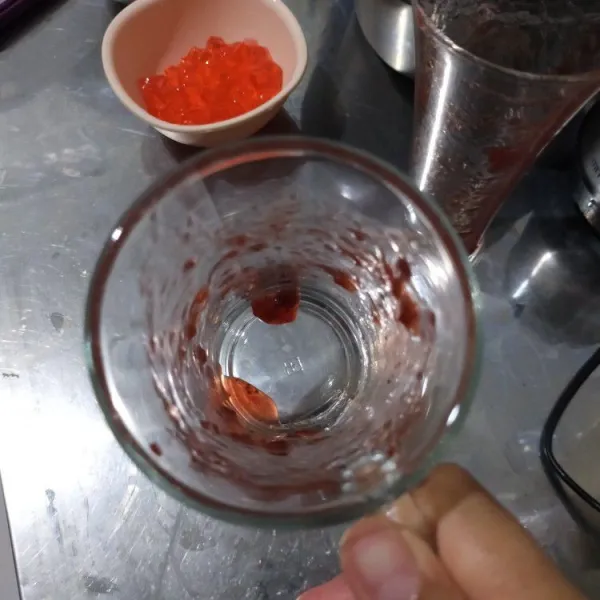 Ambil gelas saji, hias dindingnya dengan selai strawberry yang sudah di sisihkan tadi.