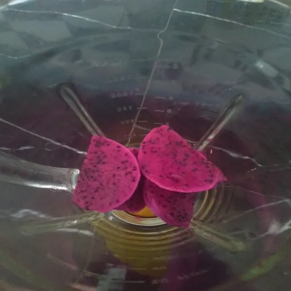 Potong, lalu kupas buah naga, lalu masukkan ke dalam blender.