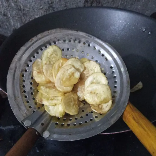 Goreng keripik pisang hingga kering dan matang, lalu angkat dan tiriskan.