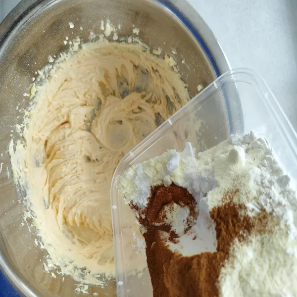 Masukkan tepung terigu, susu bubuk, baking powder dan cinammon powder. Aduk rata dengan spatula.