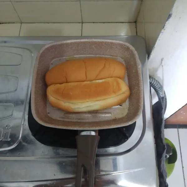Masak roti di atas pan dengan margarin.