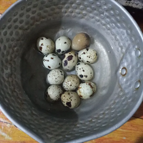 Rebus telur puyuh hingga matang, tiriskan. Lalu rendam dengan air matang selama 10 menit.