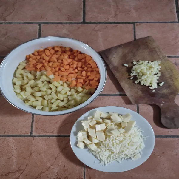 Bersihkan wortel dan kentang kemudian potong dadu lalu rebus hingga matang. Parut keju cheddar, potong dadu keju quick melt dan cincang bawang putih, sisihkan.
