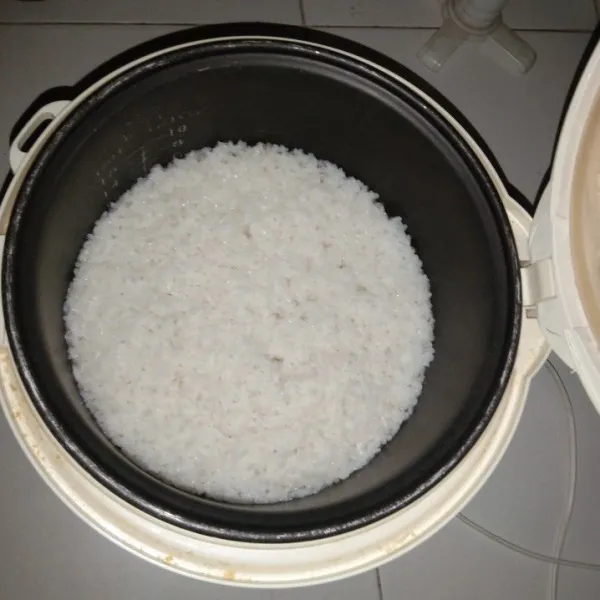 Siapkan beras, lalu cuci bersih beras. Tambahkan air, masukkan ke dalam rice cooker dan tunggu hingga nasi tanak.