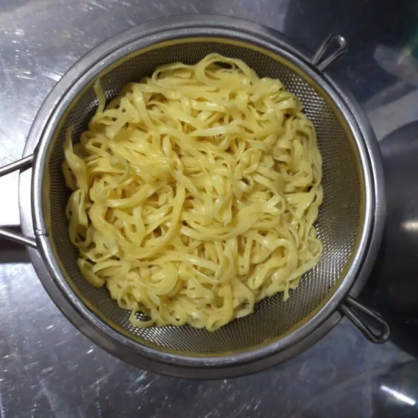 Seduh mie kuning basah dengan air panas sebentar saja lalu tiriskan.
