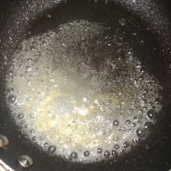 Siapkan gula pasir dan air. Masak dengan api kecil hingga gula mencair.