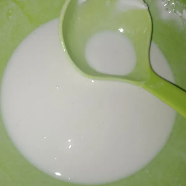 Tambahkan santan instan, aduk rata hingga tidak ada yang bergerindil. Diamkan selama 20 menit hingga bahan adonan berbuih.