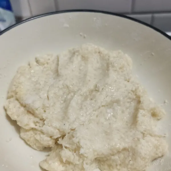 Masukkan air kelapa sedikit demi sedikit sampai kalis.