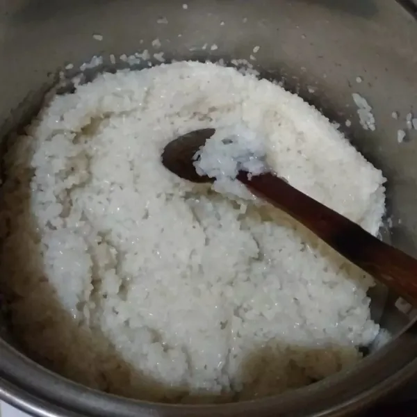 Cuci bersih beras ketan yang sudah direndam tadi, tiriskan lalu aduk rata dengan garam. Kemudian rebus beras ketan dengan air. Aduk-aduk terus agar bagian bawah tidak gosong. Masak hingga air meniris (seperti: mengaron nasi).