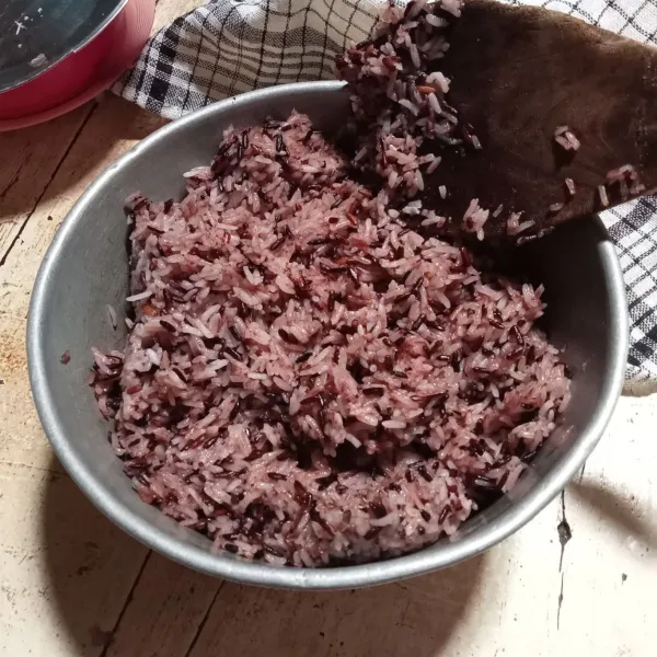 Masak beras ketan item, garam, santan dan daun pandan hingga santan menyusut. Pindahkan ke panci kukusan. Kukus selama 25 menit. Setelah matang, tambahkan gula pasir. Aduk hingga tercampur. Sisihkan.