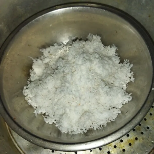 Siapkan kelapa parut, lalu beri sejumput garam, aduk lalu kukus selama 10 menit.