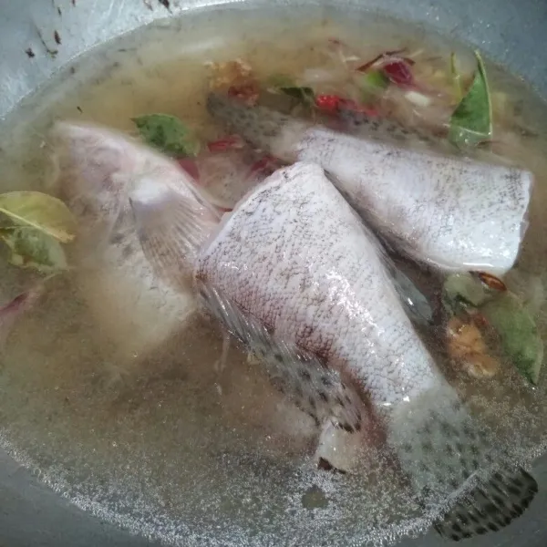 Tambahkan air, masukkan ikan kerapu bumbui lada bubuk, gula, garam dan kecap ikan aduk rata koreksi rasa