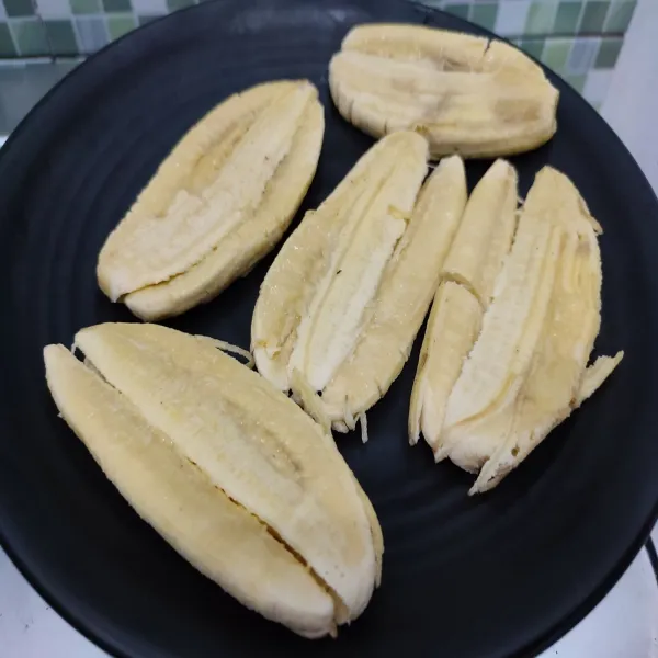 Gapit pisang menggunakan talenan, panggang di atas teflon.