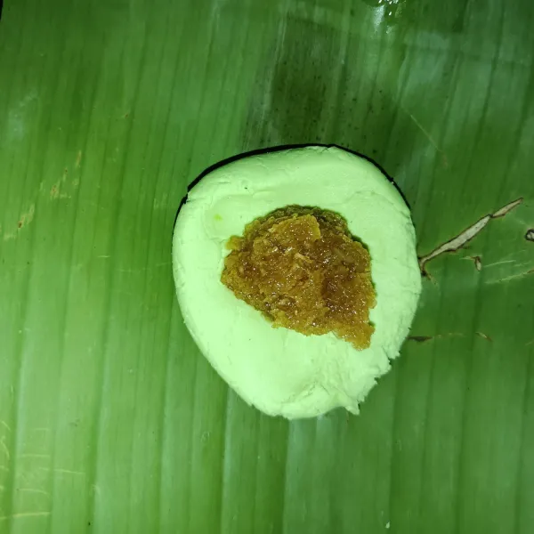 Ambil secukupnya adonan lalu isi dengan kelapa, bungkus dengan daun pisang.