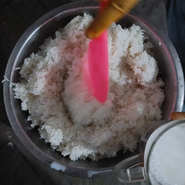 Angkat beras ketan yang telah dikukus, lalu tambahakan sejumput garam dan santan, aduk hingga rata.