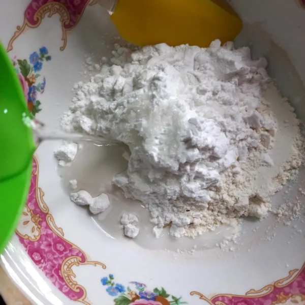 Tambahkan air sedikit demi sedikit sampai adonan kalis.