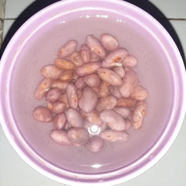 Rendam kacang merah semalaman agar mudah lunak saat direbus.