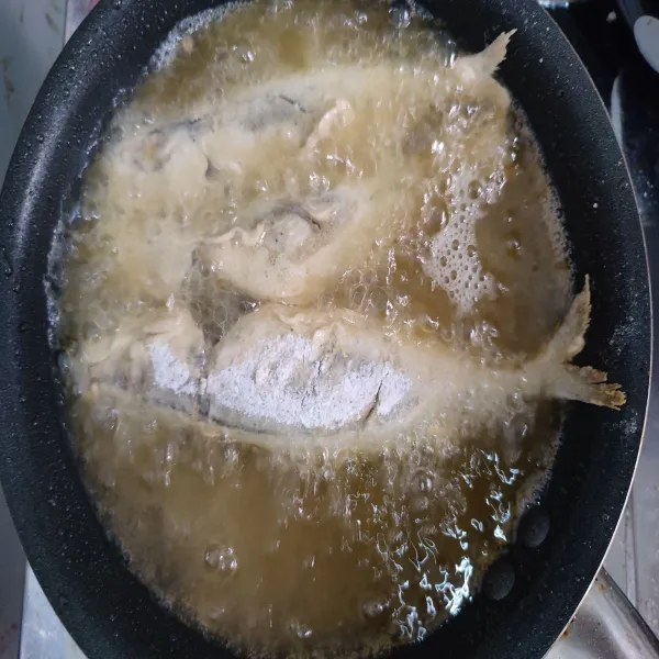 Panaskan minyak goreng, jika sudah panas kecilkan api. Kibaskan ikan, lalu goreng hingga garing.