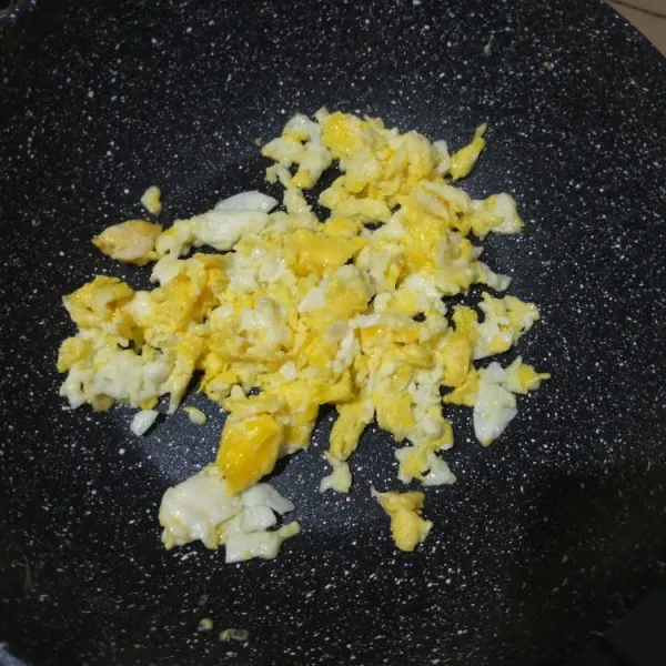 Panaskan minyak di wajan, masukkan telur, lalu buat orak-arik. Kemudian pinggirkan ke sisi wajan.