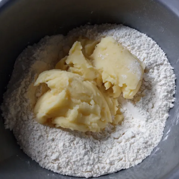 Campur tepung cakra, tepung maizena, susu bubuk, gula pasir dan fermipan, aduk rata. Tambahkan kentang dan kuning telur, ulen sampai bergerindil.