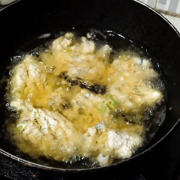Siapkan minyak goreng, goreng adonan tahu ikan pada minyak panas, gunakan api sedang agar matang merata. Angkat tiriskan dan siap disajikan.