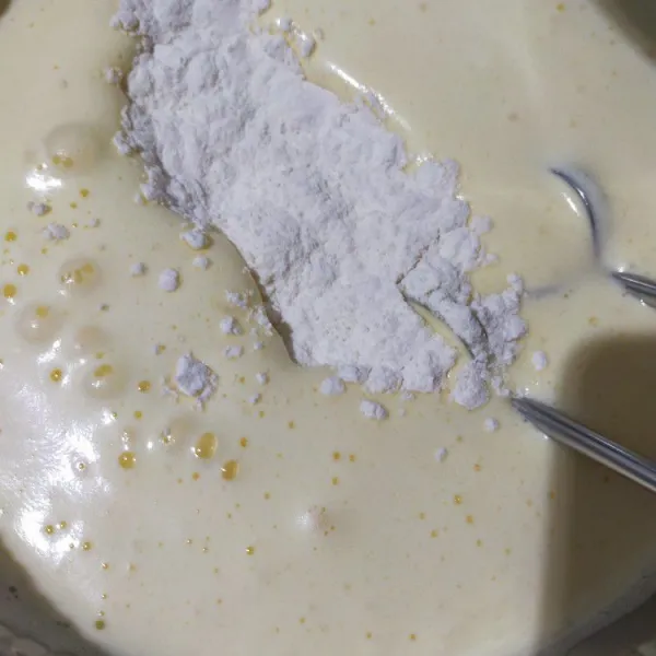 Turunkan speed mixer ke paling rendah, kemudian masukkantepung  terigu, lalu kocok rata.