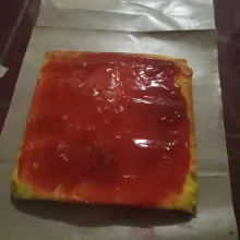 Keluarkan dari loyang saat mulai hangat, ambil kertasnya pelan-pelan. Tunggu dingin, lalu olesi dengan selai strawberry.