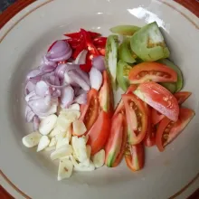Iris tipis bawang merah dan bawang putih, lalu potong-potong tomat dan cabai.