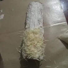 Buka bungkusan bolu gulung, lalu olesi dengan butter cream dan taburi keju parut. Kemudian potong sesuai selera dan sajikan.