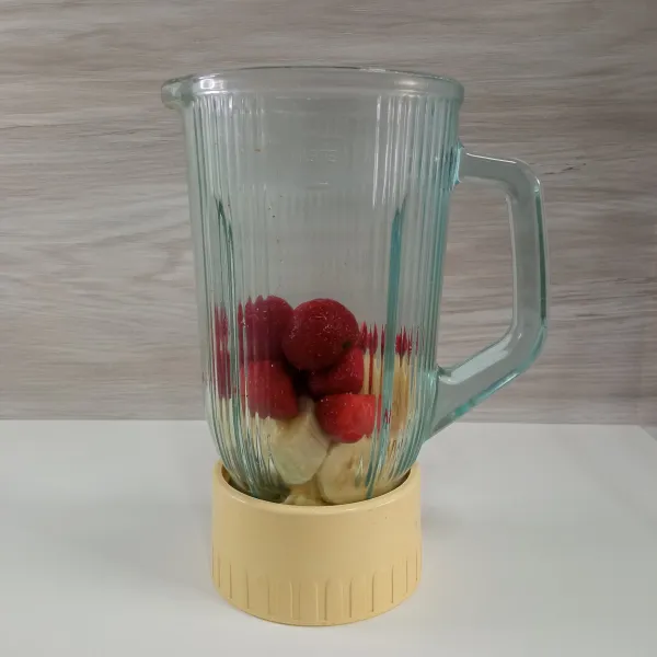 Masukkan buah pisang dan strawberry ke dalam blender.