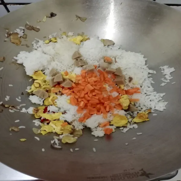 Masukkan nasi, wortel dan bakso lalu aduk rata.