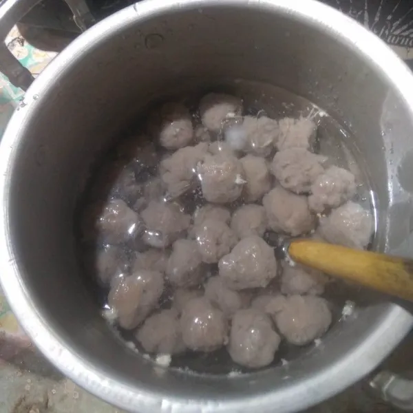 Masukkan 1 gelas es batu ke dalam 300 ml air, lalu masukkan bulatan bakso ke dalam air es. Biarkan selama 15 menit, lalu tiriskan.