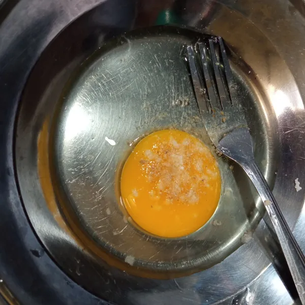 Kocok lepas telur, tambahkan garam dan merica bubuk.