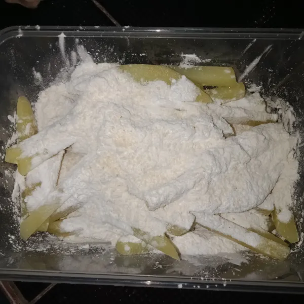 Setelah 10 menit tiriskan kentang, lalu beri tepung maizena dan kaldu bubuk, aduk rata hingga tepung maizena menempel.