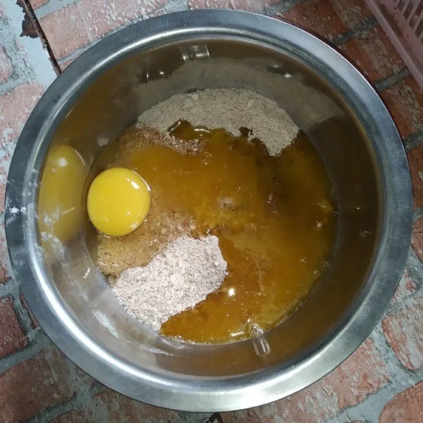 Masukkan telur dan margarin cair, aduk dengan menggunakan whisk.
